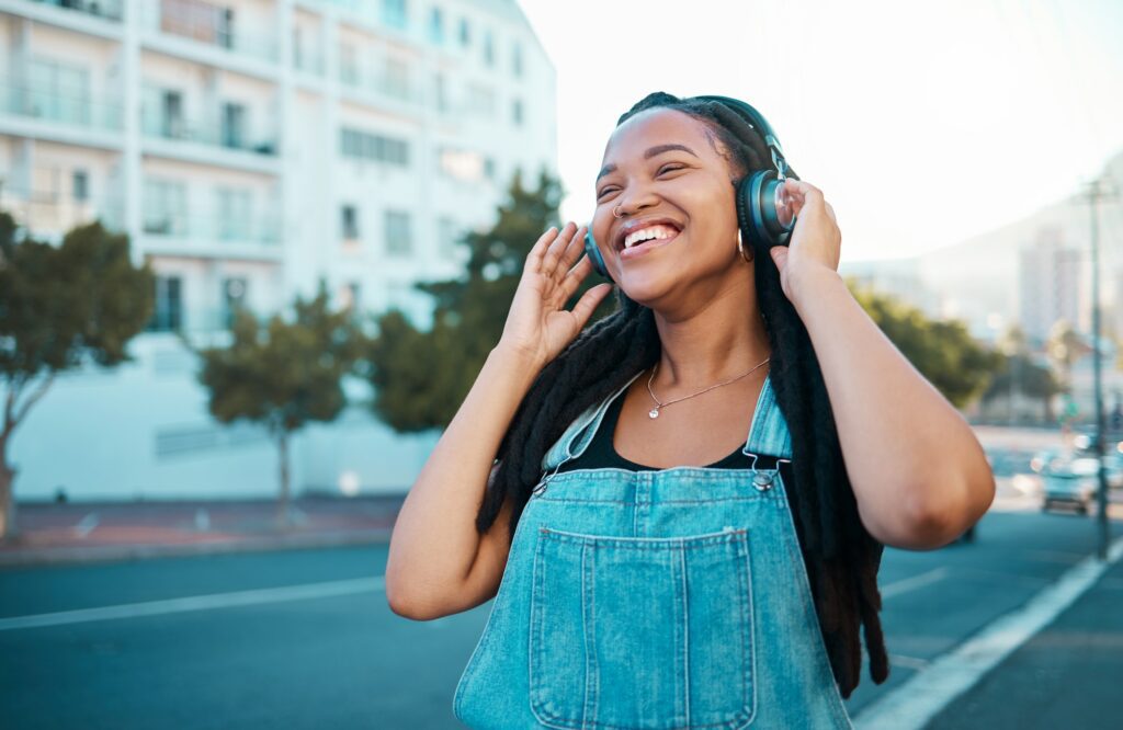 Music headphone streaming, happy and black woman smile outdoor from Atlanta. Happiness of a person in Atlanta