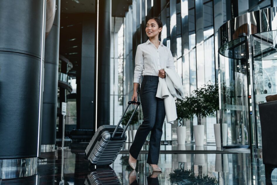 Asian female business traveler walking in Atlanta airport hotel hallway