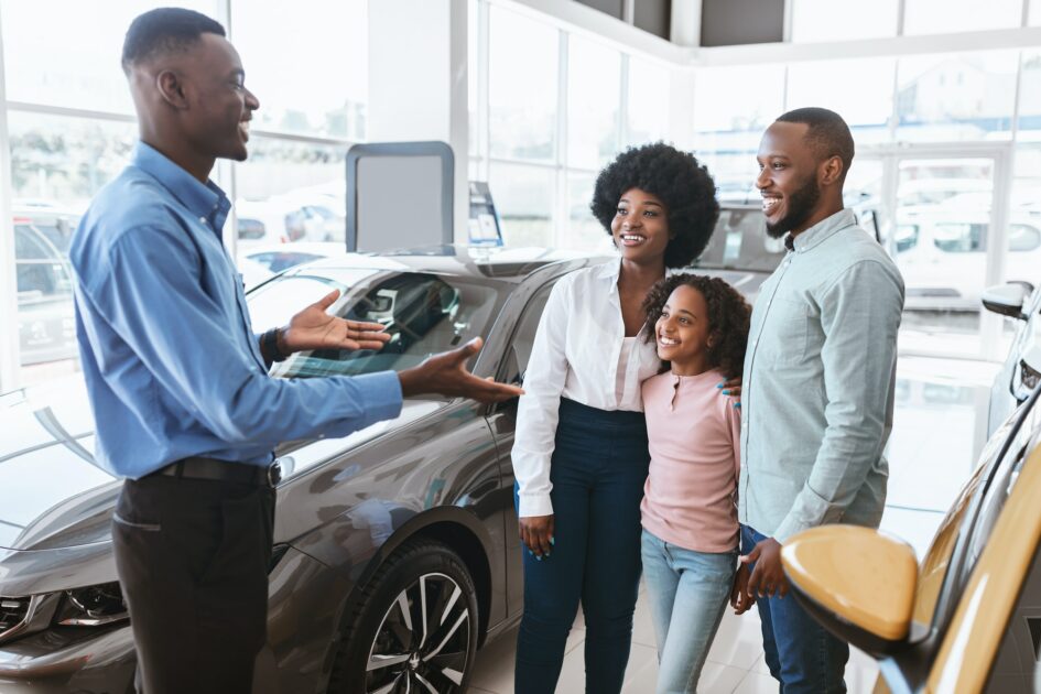 Millennial black family with kid speaking to salesman at Atlanta airport car rental