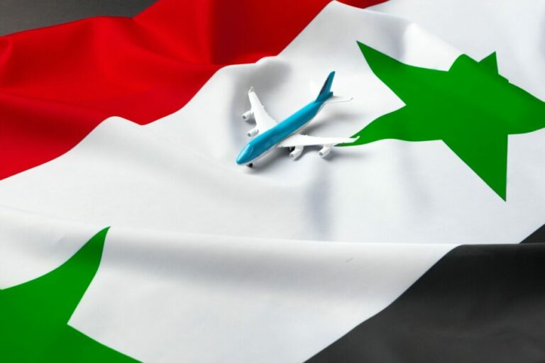 Small toy plane over the fabric flag of Syria