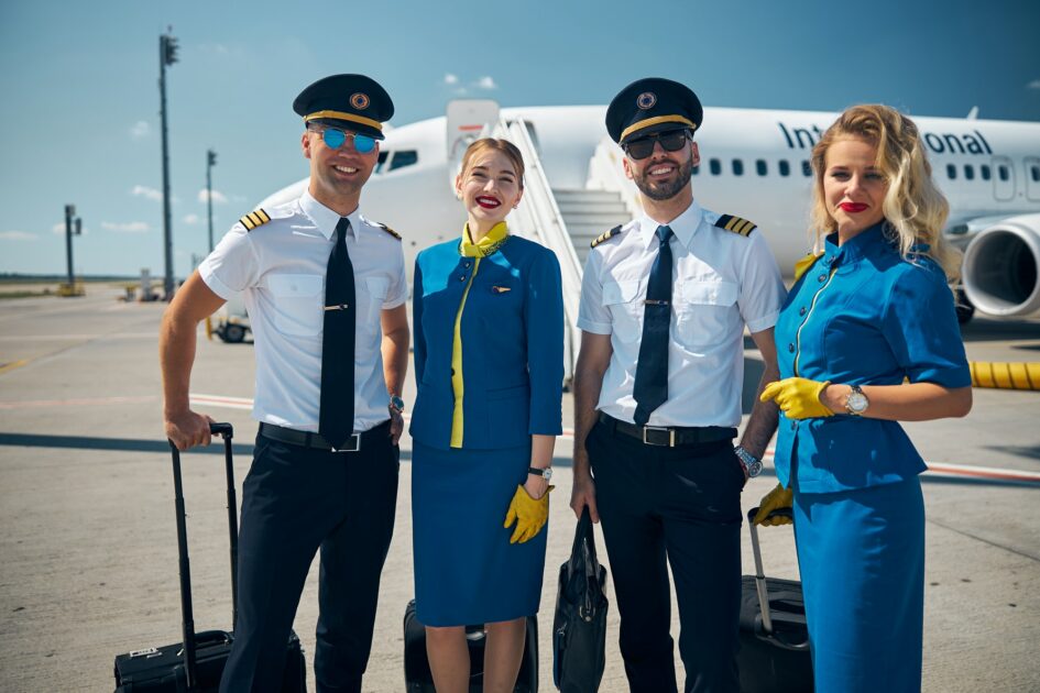 Cheerful airline workers standing in airfield before the flight