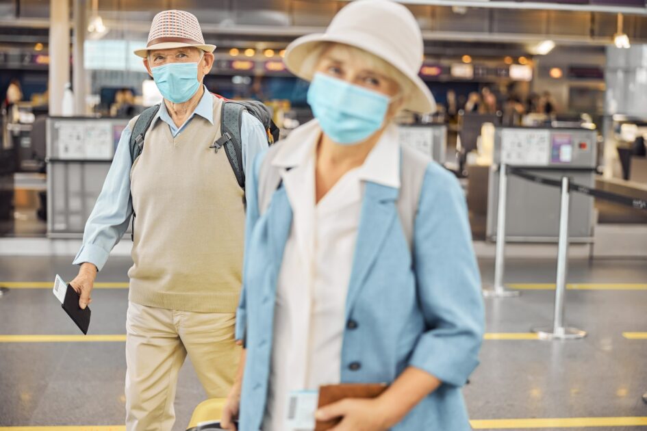 Passengers in face masks standing at the airport