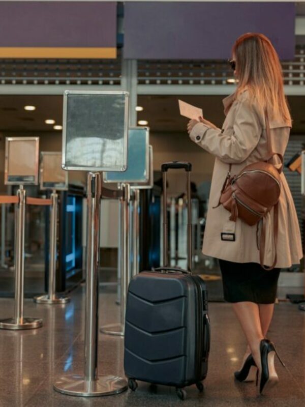Woman holding passport at customer check in of airline service counter